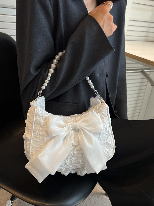 Bolso con correa al hombro con detalle de perlas y moño