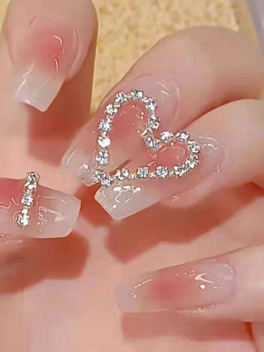 Uñas postizas con diseño de corazón con diamantes